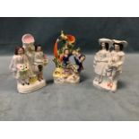 Three Victorian Staffordshire flatback couples - pair holding dogs, dancers by log spill vase, and