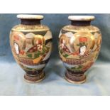 A pair of Japanese export satsuma stoneware vases decorated in raised enamelling with figures in