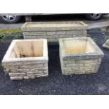 A rectangular composition stone garden planter cast with brickwork, raised on conforming stands; and