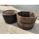 Two oak barrel plant tubs, each with staves bound by riveted metal strap bands. (25in x 16in) (2)