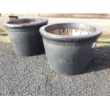 A pair of tapering stoneware garden tubs with moulded rims, finished in a metallic lead-type