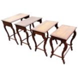 A nest of four hardwood coffee tables, the rectangular moulded tops inlaid with brass leaf