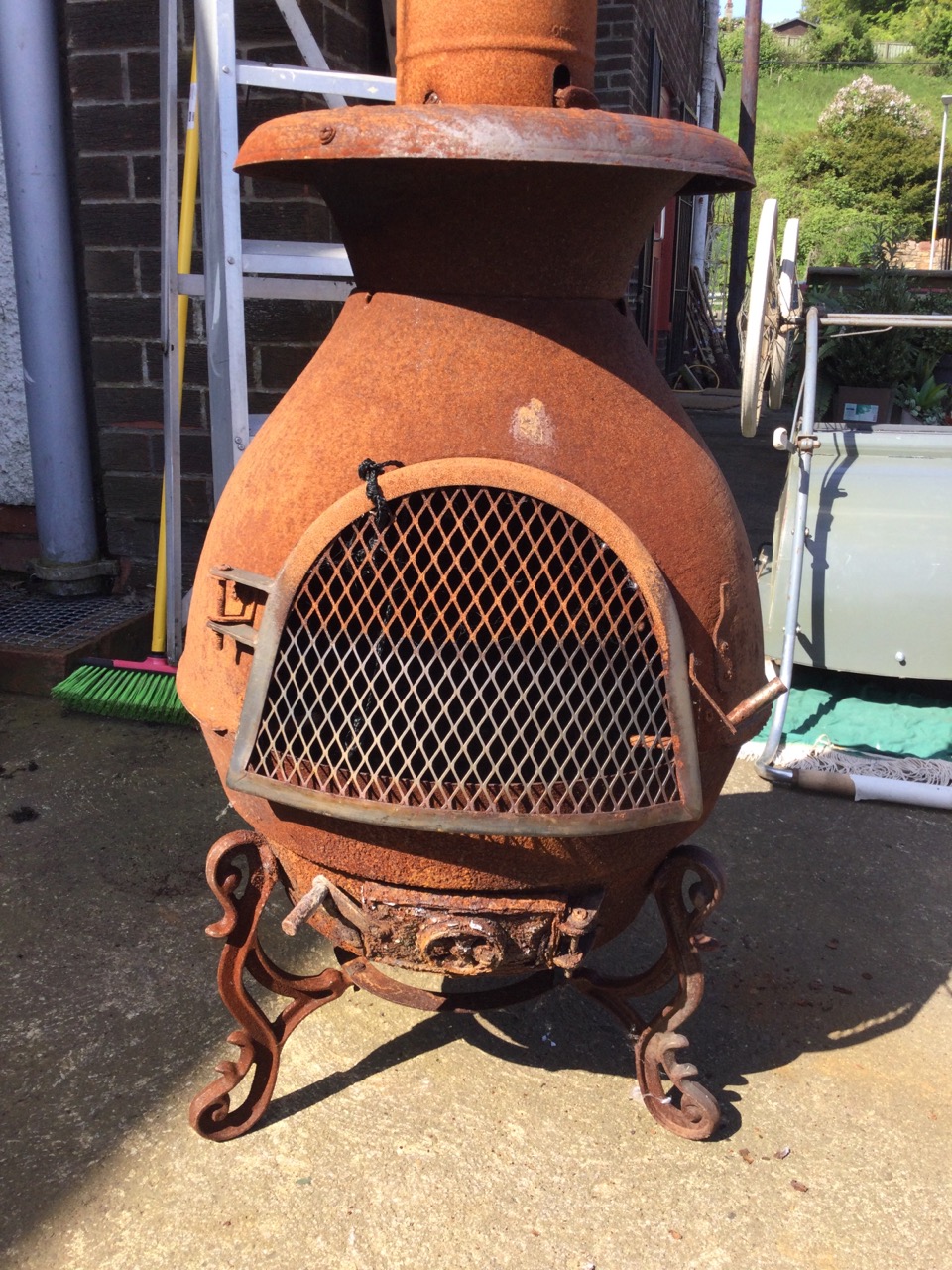 A pot-bellied garden chimera stove raised on scrolled feet, with arched mesh door and vine cast top, - Image 2 of 3