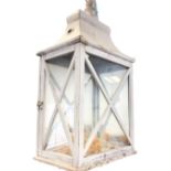A rectangular painted hanging lantern, the glazed case with hinged door having tin caddy shaped