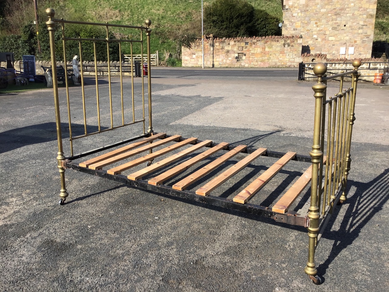 A Victorian brass bed with vertical bars to headboard & tailboard, the cornerposts with ball