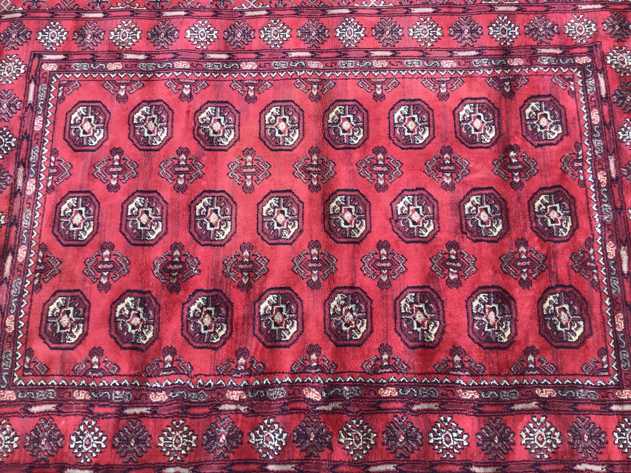 A bokarra rug woven with red field of octagonal lozenges and hooked battens within a wide border - Image 2 of 3