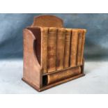 An Asprey miniature oak bookcase with eight gilt tooled leather bound reference works -