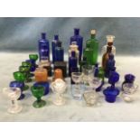 A collection of C19th glass chemists bottles, including two with original leather and wood cases,