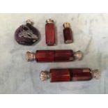 Five Victorian ruby glass scent bottles - a pair of white metal mounted double ended, two small with