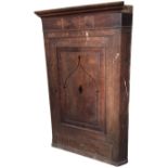 A nineteenth century oak corner cabinet with moulded cornice above a frieze set with mahogany