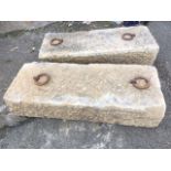 A pair of rectangular sandstone blocks, each lead set with iron rings. (35in x 13.75in x 75in) (2)