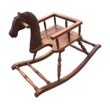 A childs carved hardwood rocking horse seat, the chair framed by turned spindles on angled turned