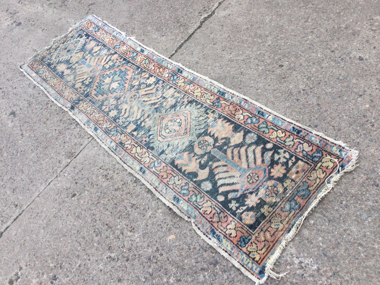 A Turkey runner woven with pendanted geometric medallions on ink-blue field, framed by border of