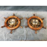 A nautical wall clock and barometer in the form of wood ships wheels centered by brass portholes. (