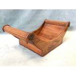 A nineteenth century mahogany cheese coaster, the crescent shaped tray with ribbed handles mounted