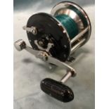 An American longbeach 66 Penn multiplier reel with nylon line, tension adjuster, brake & gears, wide