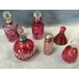 Six 19th and 20th century cranberry glass scent bottles, most with silver mounts, one with cranberry