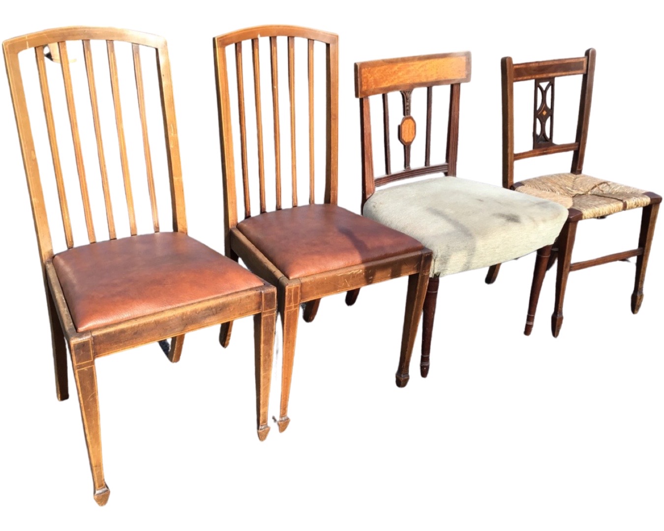 A pair of Edwardian boxwood inlaid mahogany chairs with arched spindlebacks above drop-in