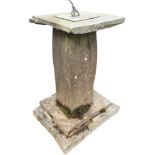 A garden sundial with bronze scrolled gnomon and square compass engraved panel mounted on granite