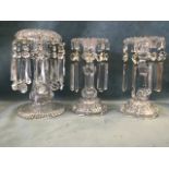 A pair of Victorian cut glass table lustre candlesticks with crystal drops, and a single larger