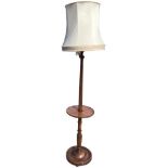 A mahogany standard lamp fitted with fabric shade, the fluted column with circular mid-tier