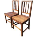 A pair of hardwood country chairs with moulded spindles to rectangular backs, the tapering solid