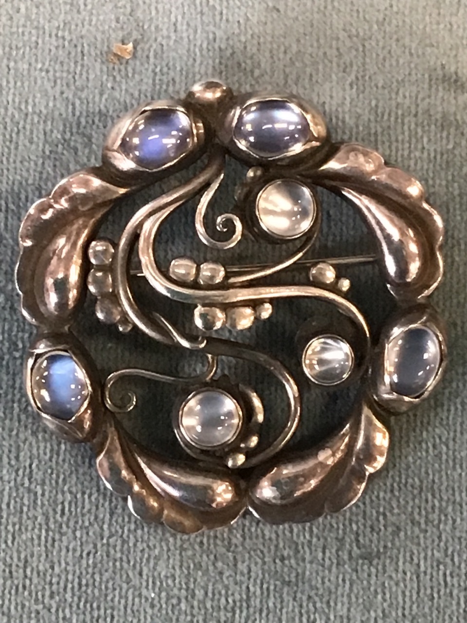 A circular Georg Jensen hallmarked silver brooch of pierced naturalistic form mounted with