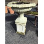 A large painted C20th composition stone garden urn, with lozenge cast rim and fluted body raised