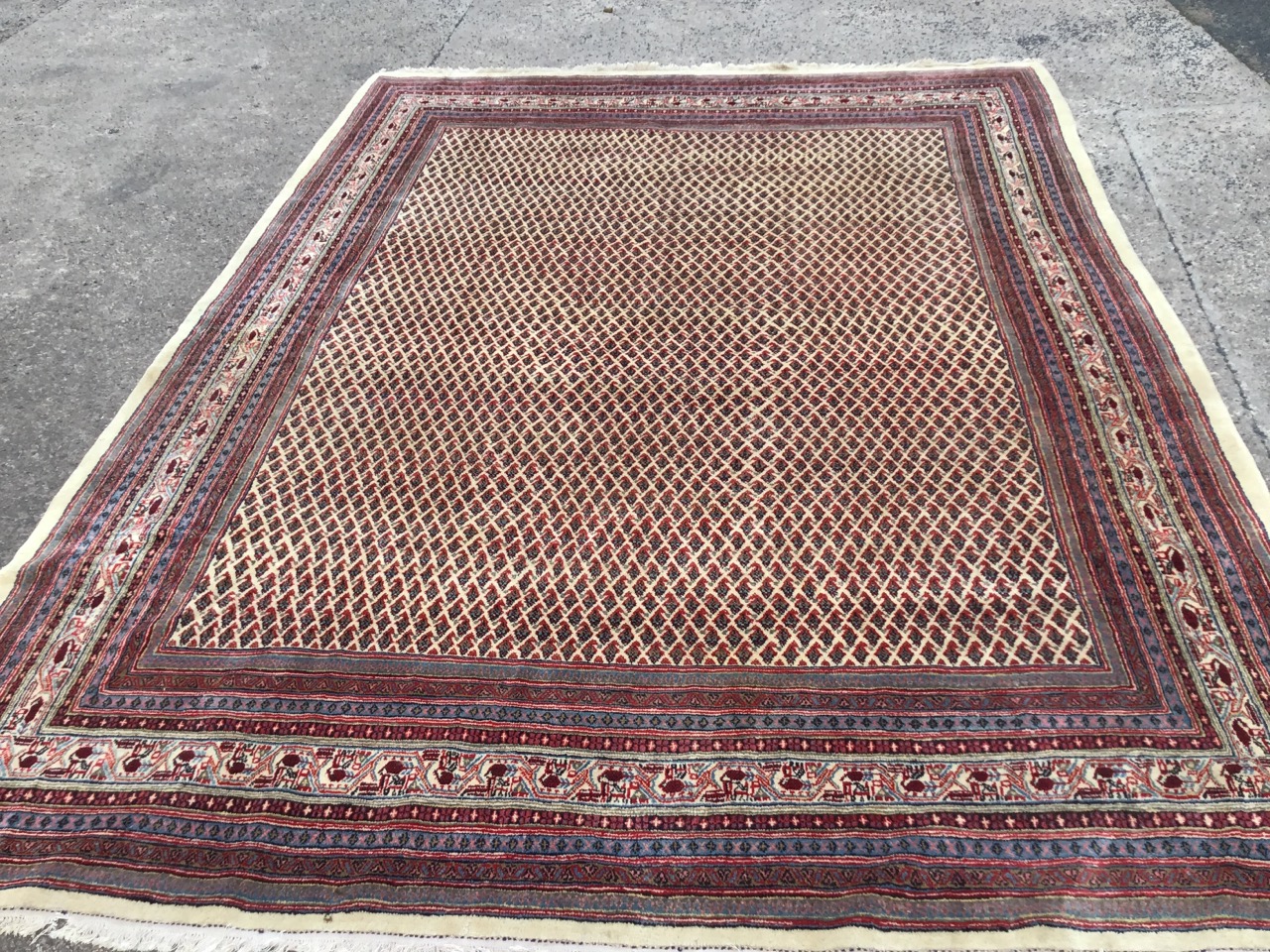 An Iranian carpet woven in the Arak style with fawn field of floral lozenges framed by multiple - Image 2 of 3