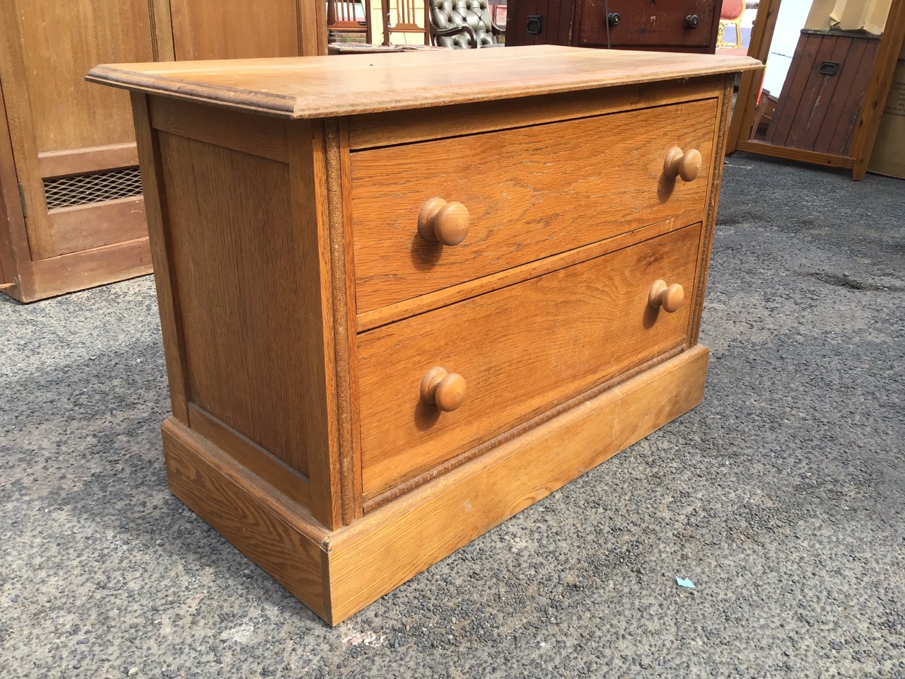 A low C20th oak chest of two knobbed drawers, with rectangular moulded top flanked by carved stiles, - Image 2 of 3