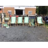 A set of six folding beech deck chairs with platform arms and striped canvas seats - some torn. (6)