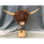 A naive carved stickwork model of a bull mounted on a stand. (23in x 25.5in)