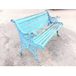 A cast iron garden bench with wood slats to back & seat, the ends decorated with pierced floral