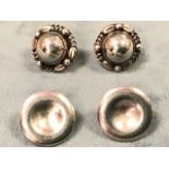 A pair of Georg Jensen silver stud earrings with mound shaped buttons framed by beads and linked