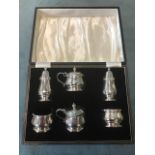 A boxed Lindisfarne style hallmarked silver condiment set with a pair of salts and mustard pots with