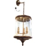 A circular brass hall lantern supported by chain from ceiling rose, the interior with three