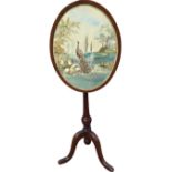 An oval mahogany polescreen, the frame on tapering column with acorn finial, having finely sewn