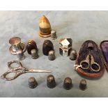 A collection of hallmarked silver sewing tools - four thimbles, two leather cased thimbles -