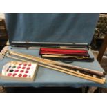 A complete boxed set of Super Crystalate snooker balls; a metal cased three-piece Riley snooker cue;