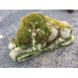A composition stone slumbering lion on rectangular plinth. (23.5in)