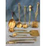 A quantity of miscellaneous brass - ladles, toasting forks, a knife sharpener with wood handle, a