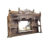 A Victorian mahogany overmantle with applied scrolled carvings and bands of gallery spindles above a