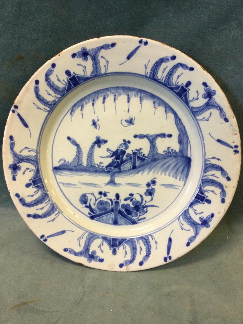 A C18th English delft tin-glazed charger with hand-painted blue & white chinoiserie decoration of