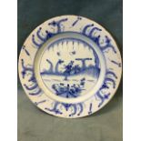 A C18th English delft tin-glazed charger with hand-painted blue & white chinoiserie decoration of