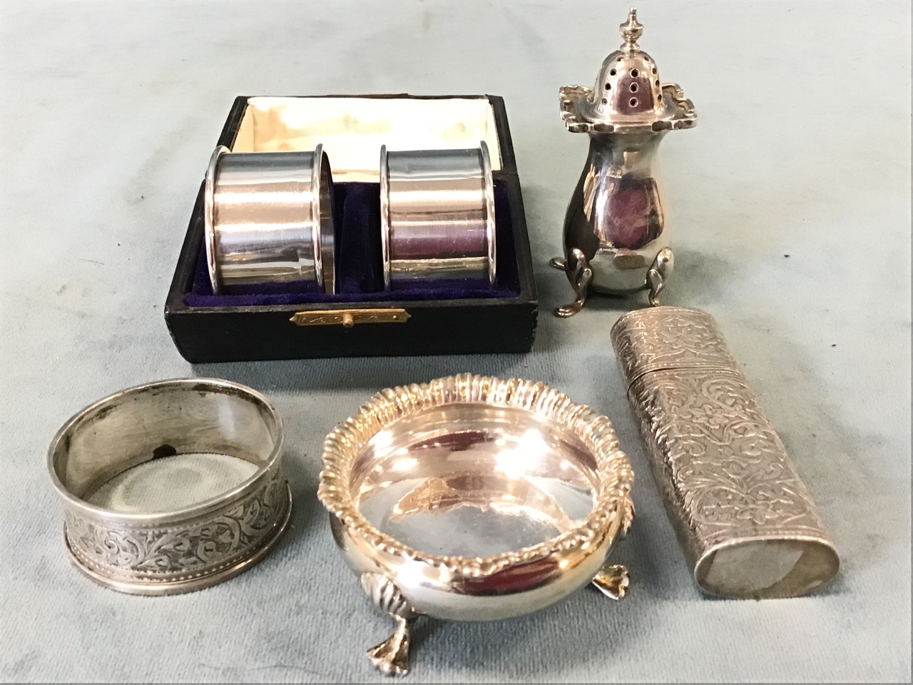 A case pair of Scottish silver napkin rings; a Birmingham hallmarked cauldron shaped salt on hoof