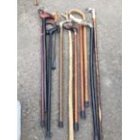 A bundle of sticks - walking, a thumbstick, two with painted duck-heads, a shoehorn, a deers foot