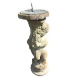 A composition stone garden sundial, the octagonal brass face with roman chapters and pierced leaf