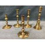 A pair of early brass candlesticks with scalloped rims and bases, having knopped columns and tubular