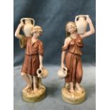 A pair of Royal Dux figurines, the watercarriers with pitchers standing on circular naturalistic