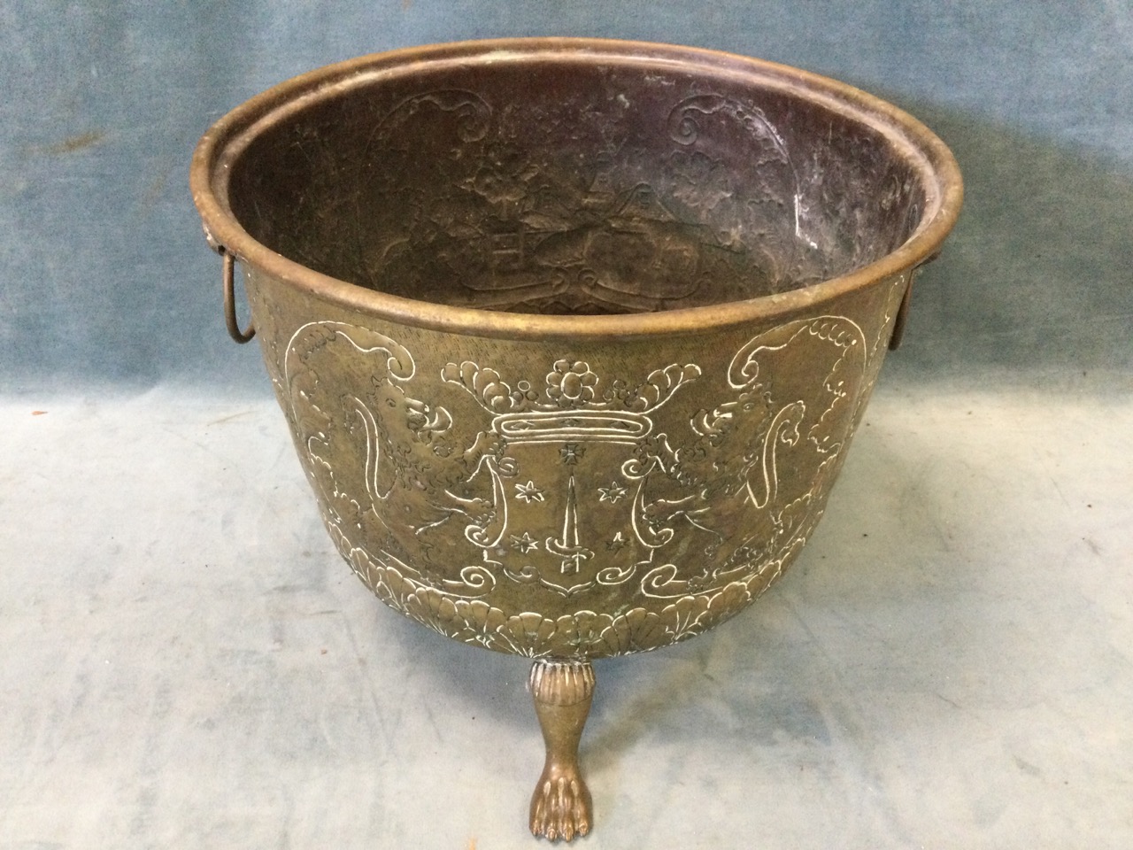 A nineteenth century embossed brass log bin raised on paw feet, the sides with lionmask ring handles - Image 3 of 3